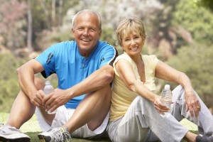 Couple assis qui se repose et boit de l'eau après du sport