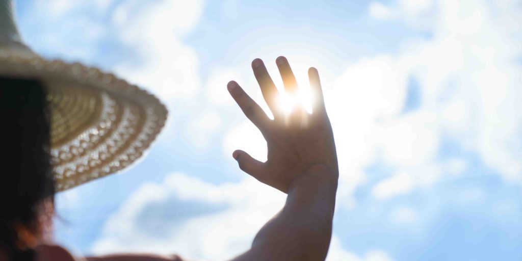 Femme se cachant du soleil avec sa main forte chaleur