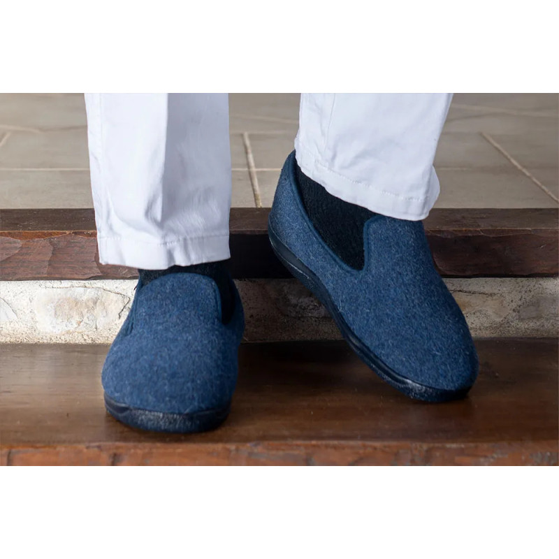 Homme portant des charentaises Airplum bleu marine sur des marches à la maison