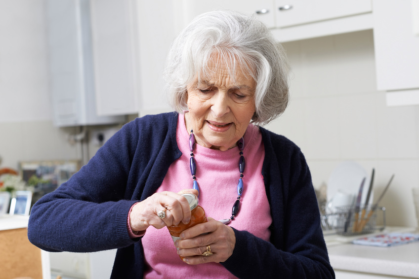 Femme âgée qui a du mal à ouvrir un pot